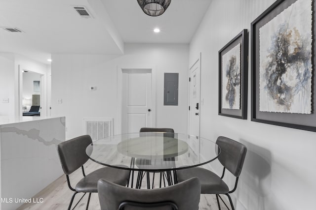 dining space featuring electric panel and light hardwood / wood-style floors