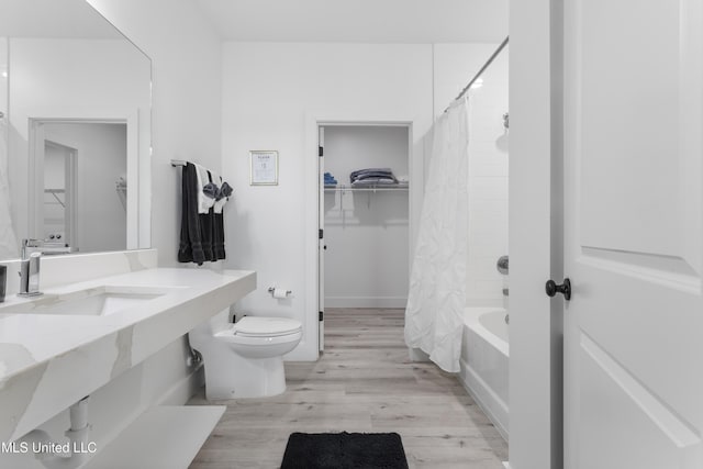 full bathroom featuring toilet, sink, hardwood / wood-style floors, and shower / bath combo