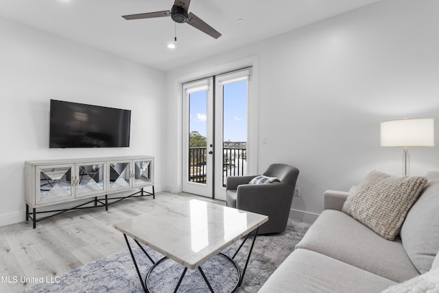 living room with french doors, ceiling fan, and light wood-type flooring