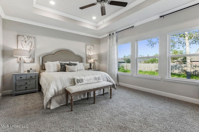 bedroom featuring multiple windows, crown molding, and a raised ceiling