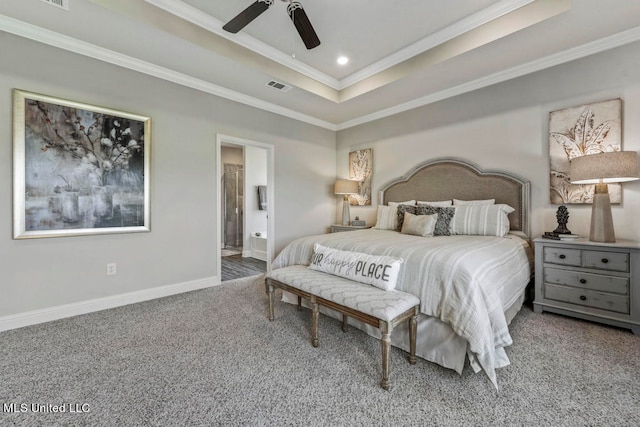 bedroom featuring ensuite bathroom, ornamental molding, a tray ceiling, carpet floors, and ceiling fan