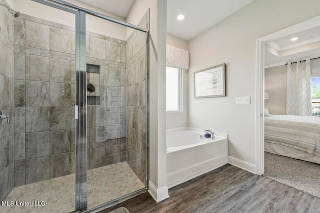 bathroom featuring hardwood / wood-style flooring, plenty of natural light, and independent shower and bath