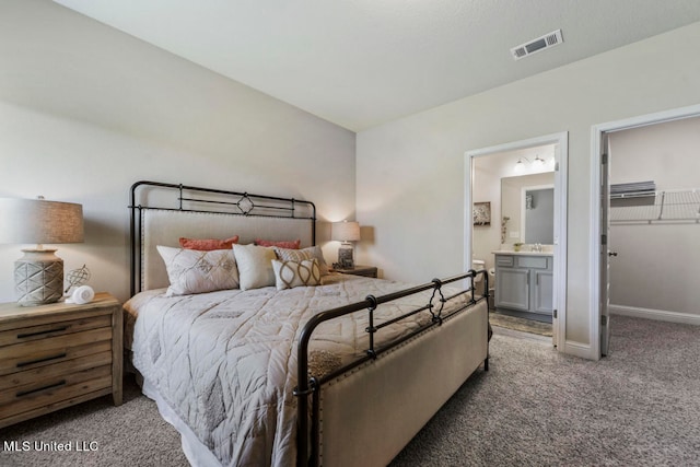 bedroom featuring a walk in closet, carpet flooring, and connected bathroom