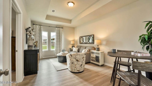 bedroom featuring light hardwood / wood-style flooring and a raised ceiling