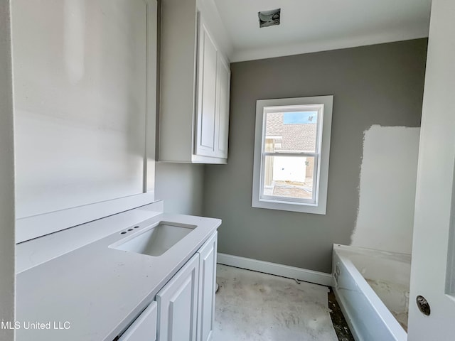 501 Harper Cv, Flowood, MS 39232 - bathroom with vanity, a tub to relax in, baseboards, and unfinished concrete floors
