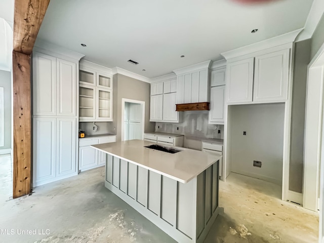 501 Harper Cv, Flowood, MS 39232 - kitchen featuring unfinished concrete flooring, a kitchen island, white cabinets, and crown molding