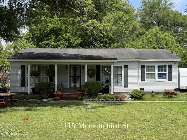 ranch-style house featuring covered porch, a front lawn, and roof with shingles