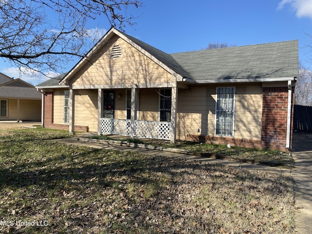 ranch-style home with a front yard and covered porch