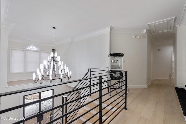 stairs featuring wood-type flooring, crown molding, and a chandelier