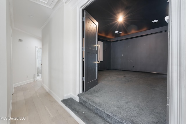 corridor with light hardwood / wood-style flooring and ornamental molding