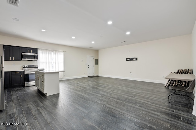 kitchen with dark wood-type flooring, a center island, and appliances with stainless steel finishes