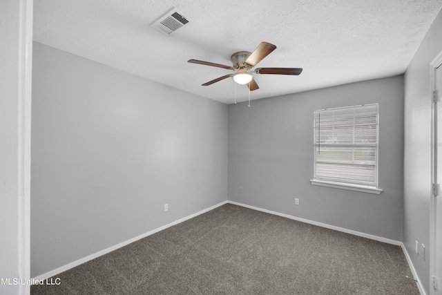 empty room featuring dark colored carpet, visible vents, baseboards, and ceiling fan