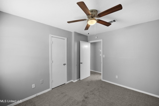 unfurnished bedroom with baseboards, a ceiling fan, visible vents, and carpet floors
