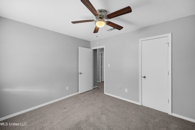 unfurnished bedroom with carpet flooring, visible vents, baseboards, and a ceiling fan