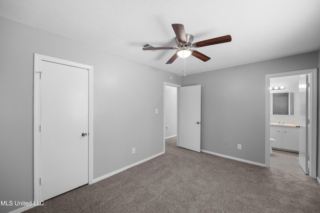 unfurnished bedroom with baseboards, a sink, a ceiling fan, carpet floors, and connected bathroom