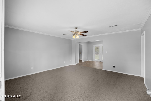 empty room with dark colored carpet, baseboards, a ceiling fan, crown molding, and visible vents