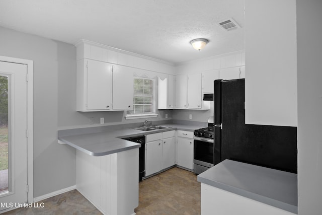 kitchen with white cabinets, gas range, dishwasher, a sink, and a peninsula