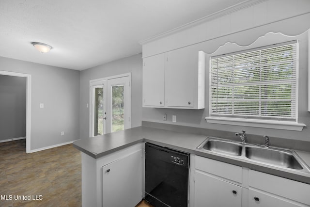 kitchen featuring baseboards, dishwasher, a sink, a peninsula, and white cabinetry