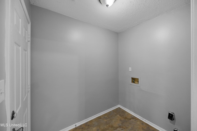 clothes washing area featuring baseboards, laundry area, a textured ceiling, and hookup for a washing machine