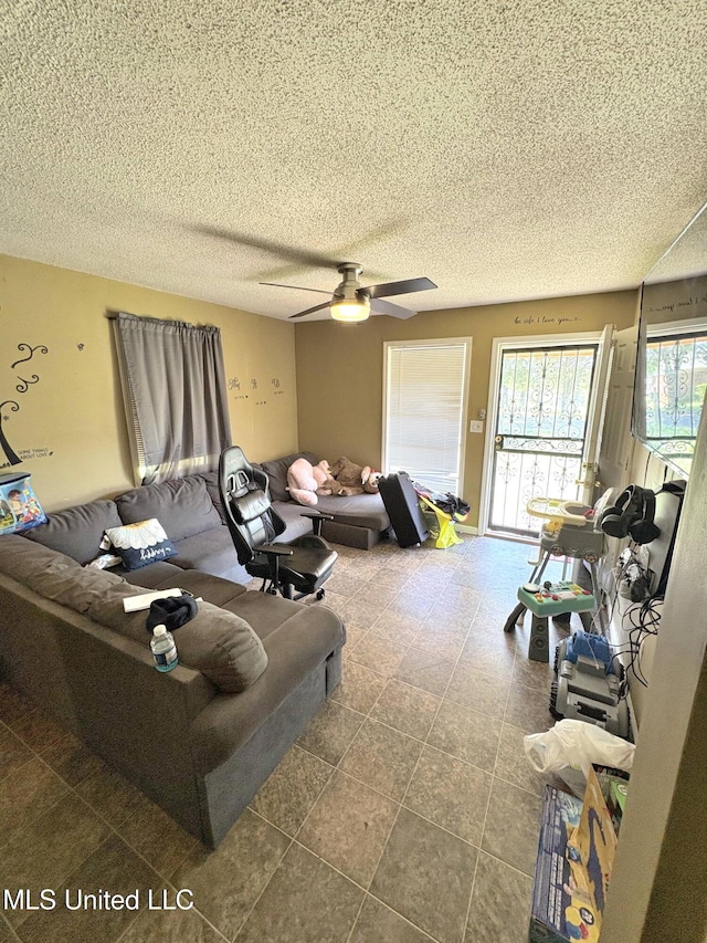 living room with a textured ceiling and ceiling fan
