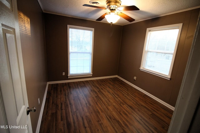 spare room with dark wood-style floors, a textured ceiling, and ornamental molding