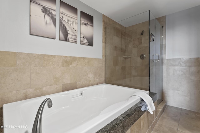 2060 Beach Blvd Unit 102, Biloxi, MS 39531 - bathroom featuring tile walls, a bath, tiled shower, and tile patterned flooring