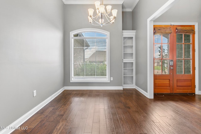 foyer with french doors, crown molding, a notable chandelier, and dark hardwood / wood-style floors