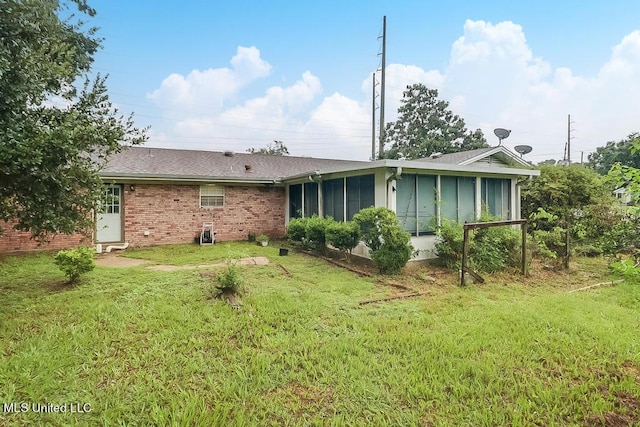 347 Rodenberg Ave, Biloxi, MS 39531 - back of property featuring a sunroom, a lawn, and brick siding