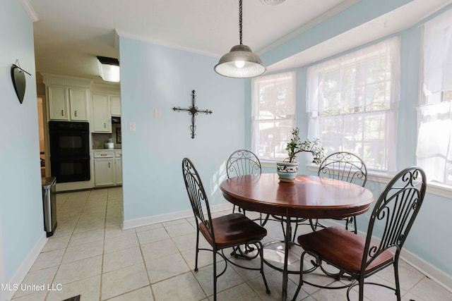 dining space featuring a wealth of natural light, crown molding, and light tile patterned floors