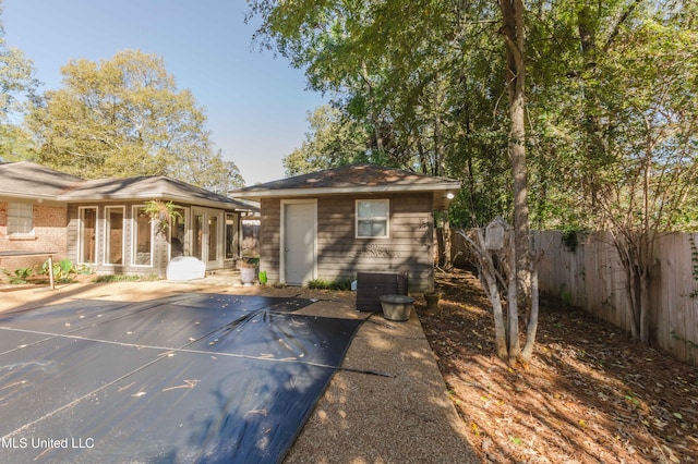 rear view of property featuring a patio area, central air condition unit, and a covered pool