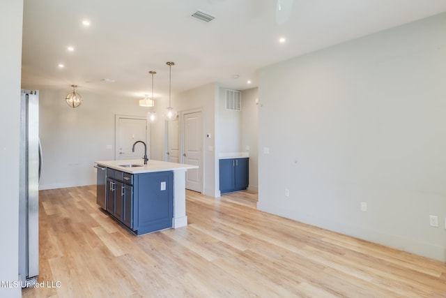 2501 Bienville Blvd Unit 334, Ocean Springs, MS 39564 - kitchen with a sink, stainless steel appliances, blue cabinets, light wood finished floors, and light countertops