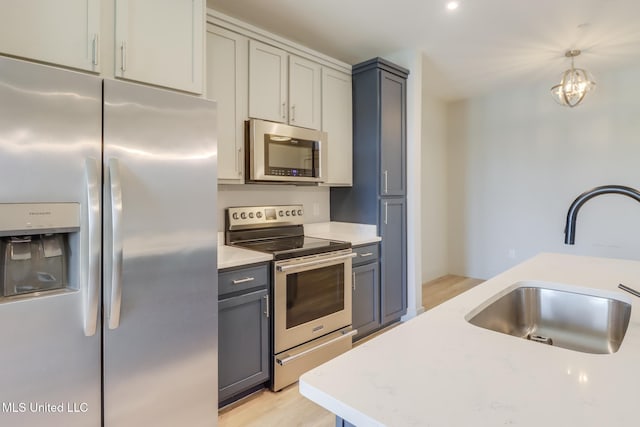 2501 Bienville Blvd Unit 334, Ocean Springs, MS 39564 - kitchen featuring stainless steel appliances, a sink, gray cabinets, pendant lighting, and light wood-style floors