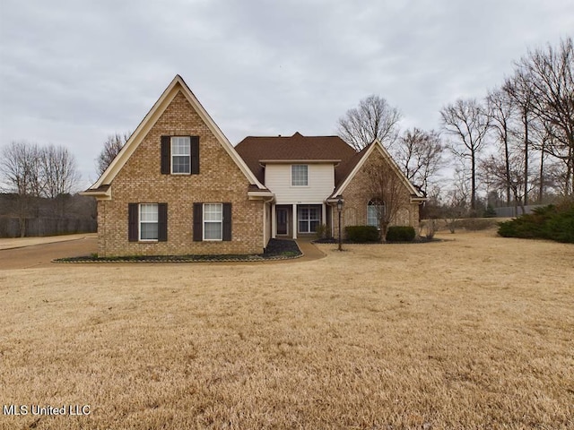 view of front of house featuring brick siding and a front lawn