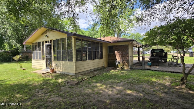 308 Walnut St, Benoit, MS 38725 - view of side of property with a sunroom, a carport, and brick siding