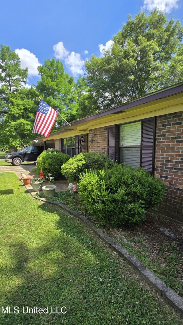 308 Walnut St, Benoit, MS 38725 - view of home's exterior featuring brick siding and a yard