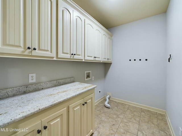 clothes washing area featuring cabinets, light tile patterned floors, hookup for a washing machine, and electric dryer hookup