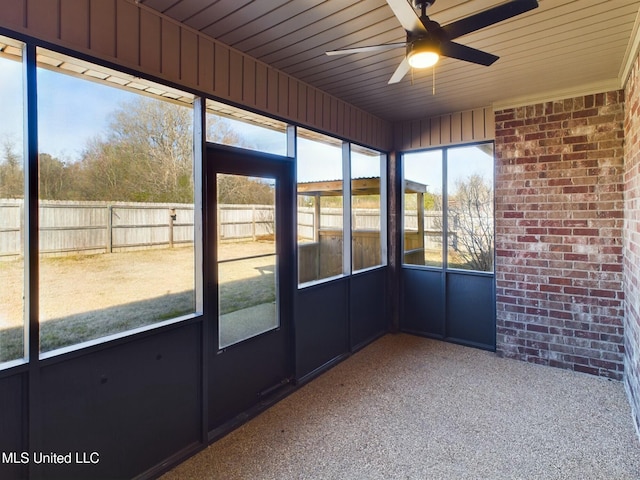 unfurnished sunroom with ceiling fan and wooden ceiling