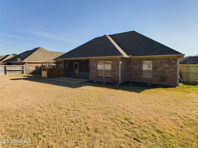 rear view of house with a yard and a patio