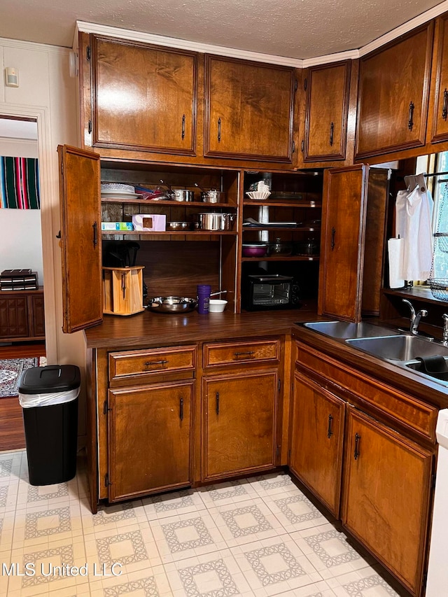 kitchen featuring a textured ceiling, white dishwasher, and sink