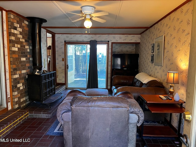 living room featuring ceiling fan, a wood stove, and crown molding