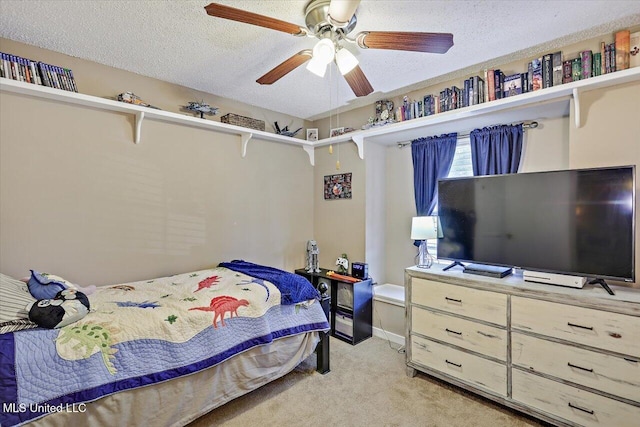 bedroom with baseboards, a ceiling fan, a textured ceiling, and light carpet
