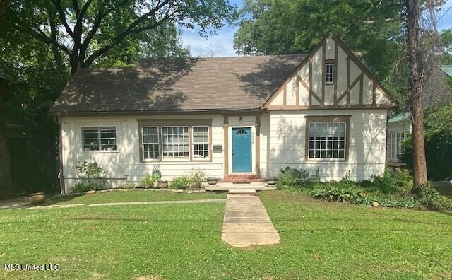 tudor-style house featuring a front lawn