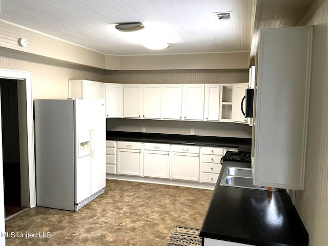 kitchen featuring sink, white cabinetry, and white refrigerator with ice dispenser