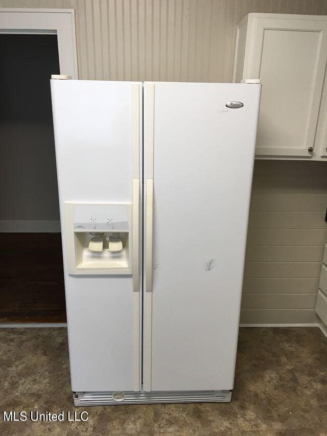 room details featuring white cabinetry and white refrigerator with ice dispenser