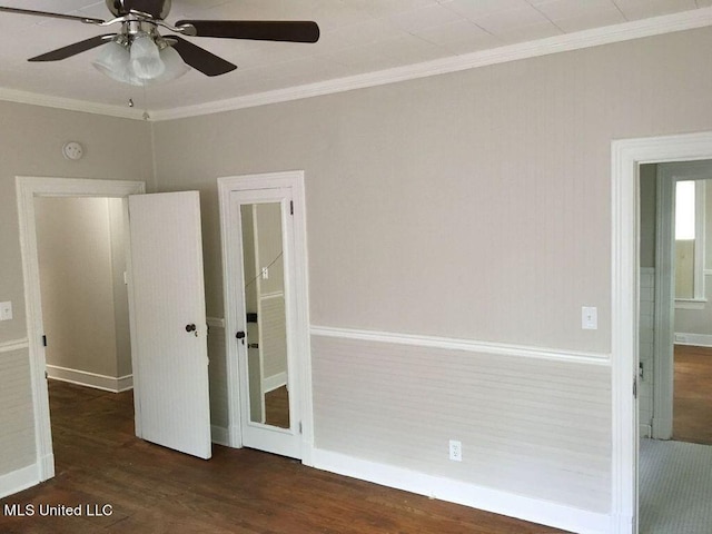 spare room featuring dark wood-type flooring, crown molding, and ceiling fan