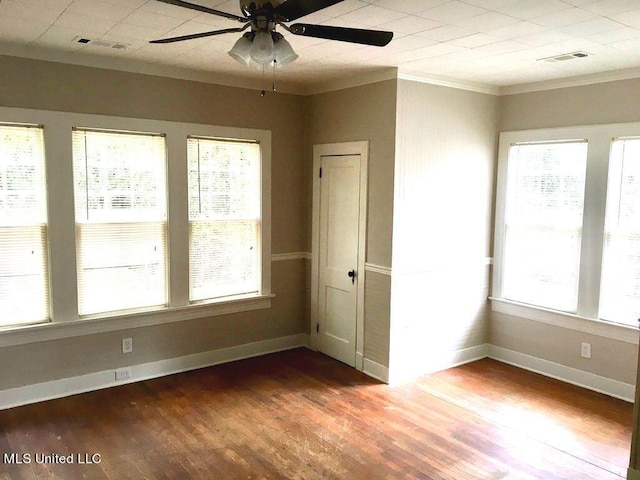 empty room with ceiling fan, hardwood / wood-style flooring, and crown molding