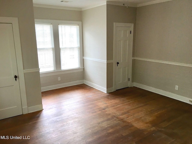 empty room featuring ornamental molding and dark hardwood / wood-style floors