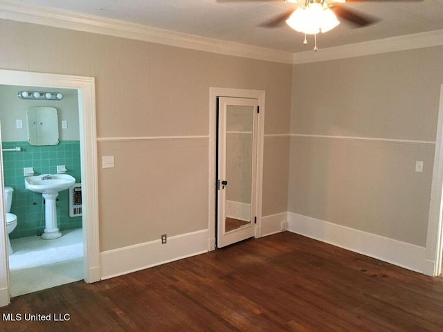 unfurnished room featuring sink, ceiling fan, tile walls, dark wood-type flooring, and crown molding