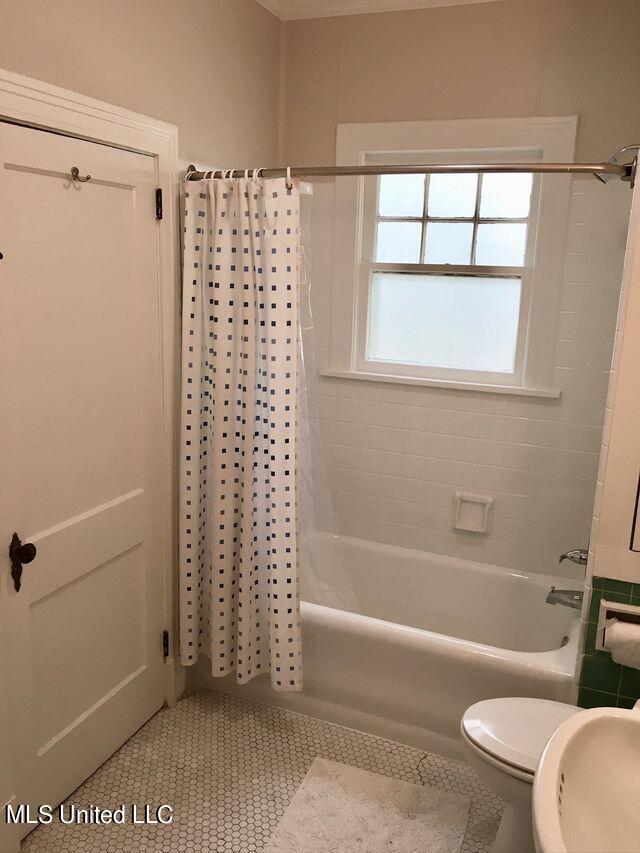 full bathroom featuring tile patterned floors, sink, toilet, and shower / bathtub combination with curtain