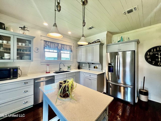 914 39th Ave, Gulfport, MS 39501 - kitchen with appliances with stainless steel finishes, a sink, ornamental molding, decorative light fixtures, and dark wood-style floors